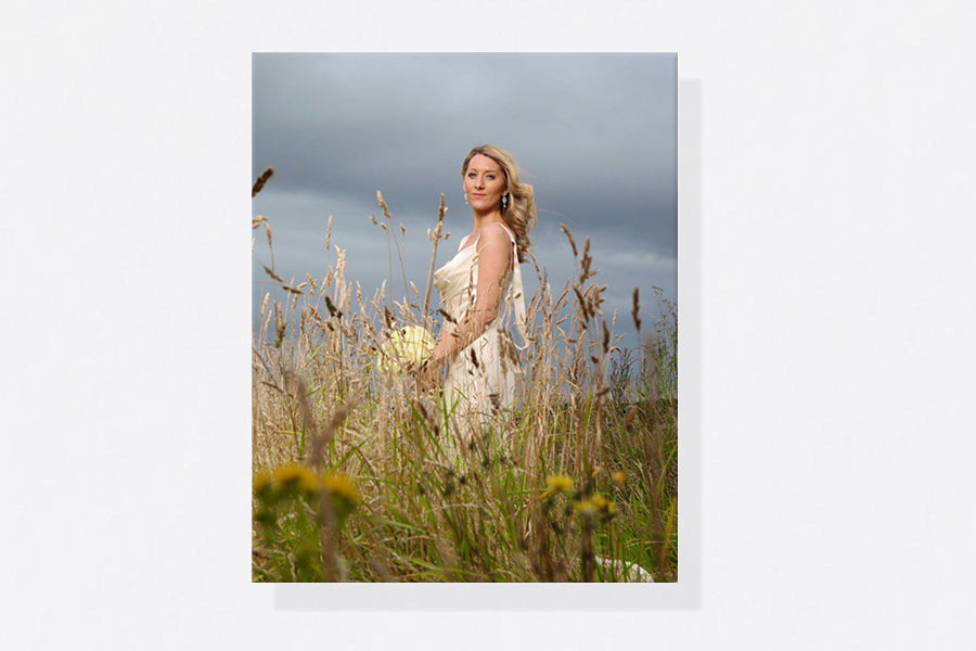 Portrait canvas print of a bride standing in a wildflower meadow