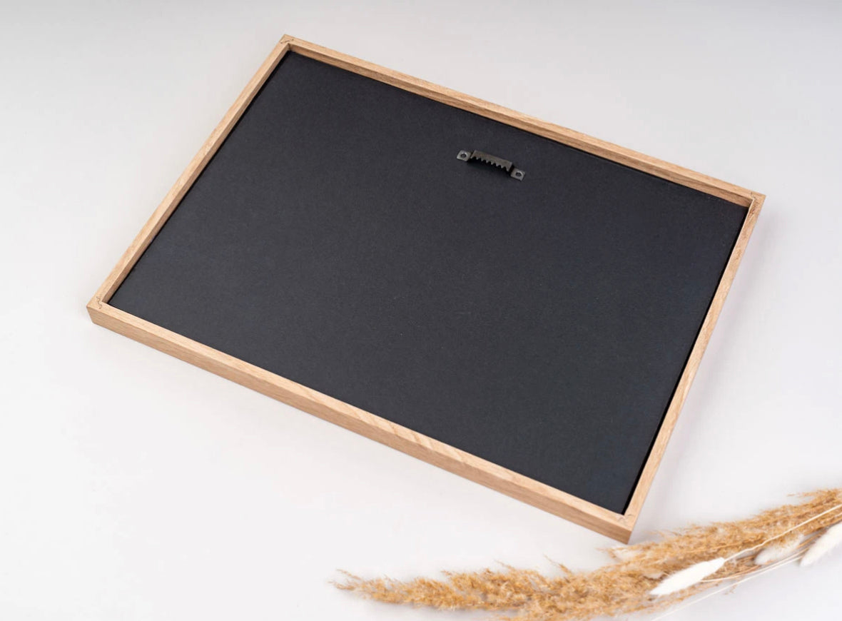 Back of a natural oak photo frame showing the hanger, ready to hang