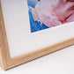 Close-up of a natural oak photo frame corner with a white mount