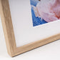 Close-up of an oak framed print with a white mount