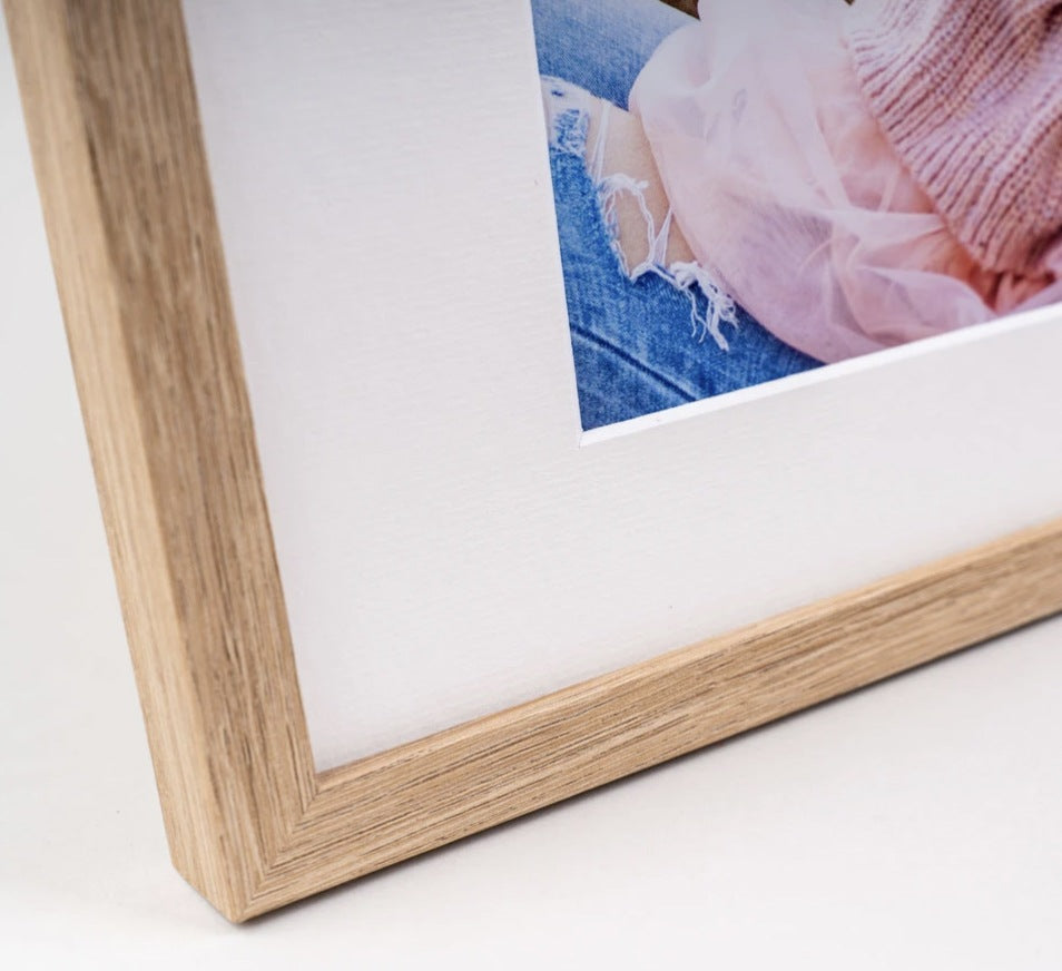 Close-up of an oak framed print with a white mount