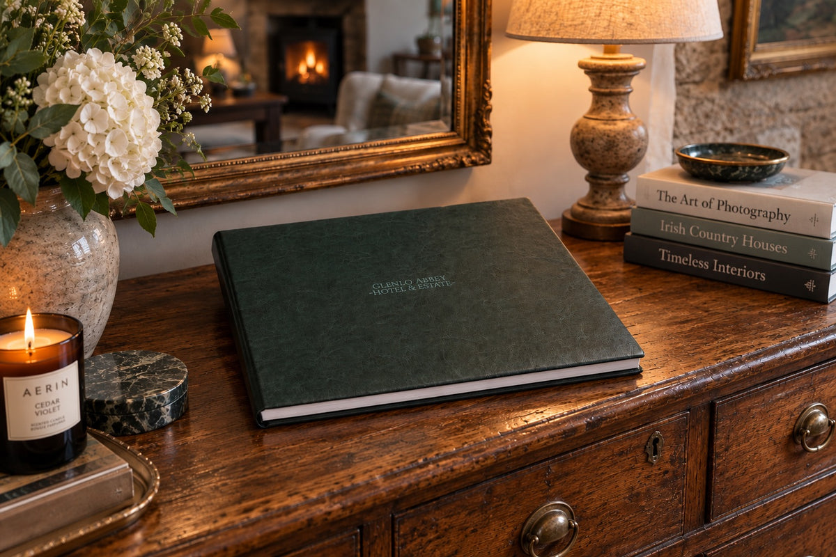 Hunter green leatherette wedding album with cover engraving on a wooden dresser in a cosy Irish home