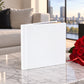 White leatherette wedding album on a marble coffee table with red roses