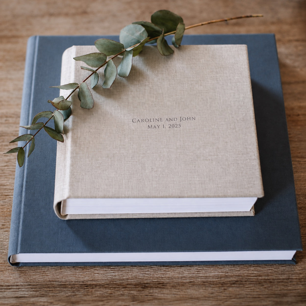 Personalised linen wedding album on a navy linen album, with eucalyptus sprig