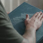 Hand brushing across a soft Robin Egg blue velvet wedding album cover to show the texture of the velvet